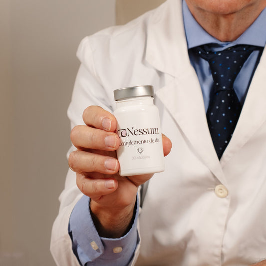 Médico con bata blanca sosteniendo el bote del Complemento de día Nessum