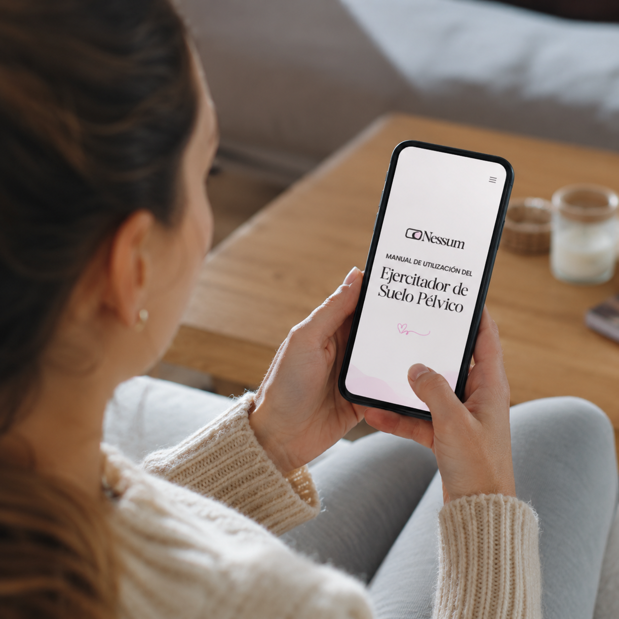 Mujer consultando la guía digital de ejercicios del ejercitador de suelo pélvico Nessum en el móvil